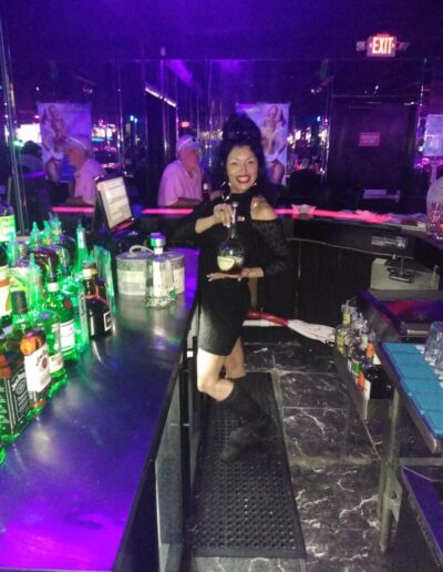 Bartender holing bottle up while posing for the camera